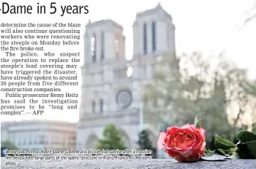  ?? — Reuters photo ?? A rose placed near Notre-Dame Cathedral is pictured at sunrise after a massive fire devastated large parts of the gothic structure in Paris, France.