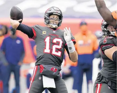  ?? DAVID ZALUBOWSKI/AP ?? Bucs quarterbac­k Tom Brady throws a pass during the Bucs’ win over the Broncos on Sunday in Denver.