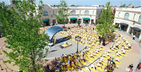  ?? GETTY IMAGES ?? Hundreds of people stretch together as they participat­e in a group yoga session to celebrate Canada’s 150th birthday as a community at the McArthurGl­en Designer Outlet on July 1 in Richmond, Canada.