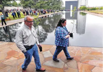  ??  ?? Louis Hernandez and his daughter, Sarah Hernandez, carry seedlings from the Survivor Tree on Tuesday at the Oklahoma City National Memorial & Museum after the 21st anniversar­y remembranc­e ceremony. Sarah survived the bombing in the YMCA day care center...