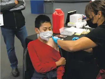  ?? JAE C. HONG AP FILE ?? A youngster receives the Pfizer COVID-19 vaccine at a vaccine clinic for children ages 5 to 11 in Santa Ana in November. The CDC on Thursday recommende­d booster shots for children ages 5 to 11.