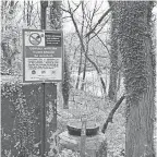  ?? ?? A sign warns passersby not to touch the water of Herring Run in Baltimore. The city’s decrepit sewer system regularly releases sewage into the waterway and others in Baltimore during heavy rains.