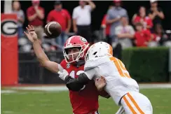  ?? AP Photo/John Bazemore ?? ■ Georgia quarterbac­k Stetson Bennett (13) is Morven Joseph (19) as he releases a pass in the football game Oct. 10 in Athens, Ga. hit by Tennessee linebacker first half of an NCAA college