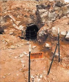  ?? Henry Brean ?? Las Vegas Review-journal Barbed wire and warning signs mark an abandoned mine shaft near Fort Apache and Warm Springs roads.