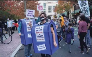  ?? Bryan R. Smith / AFP via Getty Images ?? People dressed as mailboxes dance outside the Pennsylvan­ia Convention Center as ballot counting continues inside in Philadelph­ia on Friday.