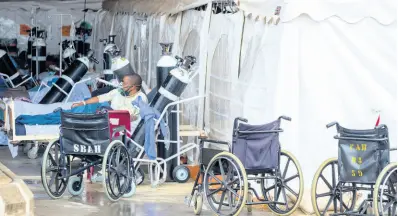  ?? AP ?? In this January 11 photo a patient wearing an oxygen mask is treated in a makeshift emergency unit at Steve Biko Academic Hospital in Pretoria, South Africa.