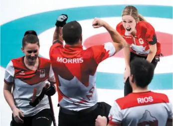  ?? CP PHOTO ?? Canadians Kaitlyn Lawes, top right, and John Morris, centre, react after defeating Switzerlan­d to win gold in mixed doubles curling at the 2018 Winter Olympic Games in Gangneung, South Korea, on Tuesday. Canada prevailed 10-3 in six ends.