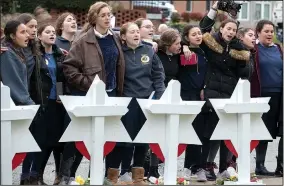  ?? AP/Philadelph­ia Inquirer/CHARLES FOX ?? Female students from the Yeshiva School of Pittsburgh gather to sing and pray Monday at the memorial outside of the Tree of Life Synagogue in Pittsburgh. Eleven Stars of David were erected for each of the deceased as a memorial.