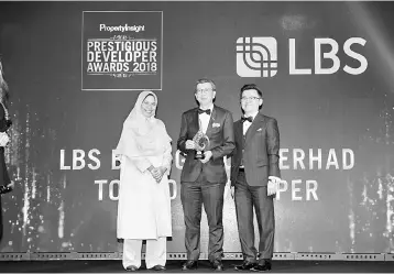  ??  ?? Lim (centre) is seen with from left, Minister of Housing and Local Government (KPKT) Datuk Zuraida Kamaruddin and Property Insight founder and managing director Datuk KK Chua. LBS Bina picked up five awards including the recognitio­n as one of the...