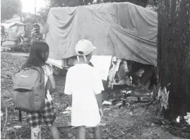  ?? (Ariel P. Avendano) ?? TWO pupils attending a Saturday makeup class stopped to take a look at the crushed van that claimed the life of a DepEd official on Friday.