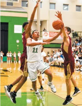  ??  ?? East Hamilton’s Justin Dozier splits a pair of Riverdale defenders for a basket on Monday.