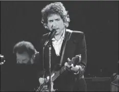  ?? AP PHOTO/JEFF ROBBINS ?? Musician Bob Dylan performs with The Band at the Forum in Los Angeles in 1974.