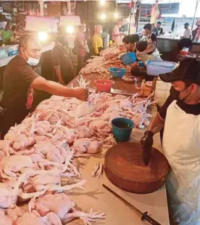  ?? (Foto Fathil Asri/bh) ?? Peniaga ayam melayan pelanggan di Pasar Datuk Keramat, Kuala Lumpur, semalam.