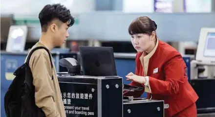  ?? BLOOMBERG PIC ?? An Cathay Pacific Airways Ltd employee assisting a customer at the Hong Kong Internatio­nal Airport. The airline suffered two ticketing errors in around two weeks.