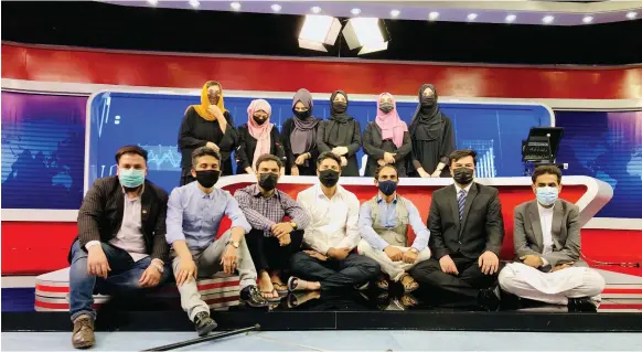  ?? EPA ?? Male staff at TOLOnews in Kabul wear masks to support their female colleagues who have been ordered by the Taliban to wear a veil while on air