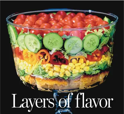  ?? STEVE MELLON/PITTSBURGH POST-GAZETTE ?? Built on a layer of savory cornbread, the summer trifle salad is made with shredded romaine lettuce, sweet corn, mini peppers, cucumbers and cherry tomatoes.