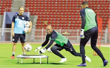  ??  ?? Oman goalkeeper Ali al Habsi (centre) goes through a drill at the Sultan Qaboos Sports Complex as goalkeepin­g coach Mabrouki Chedli (left) looks on