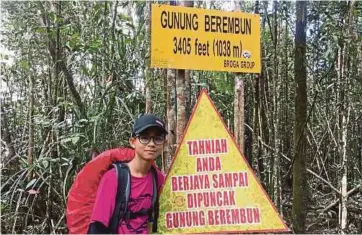  ??  ?? Akmal Hafiz bergambar kenangan selepas tiba di puncak Gunung Berembun, Negeri Sembilan yang mempunyai ketinggian 1,038 meter.