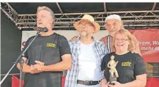  ?? FOTO: LANGE ?? Beim Straßenmus­iker-Camp ehrten Christian Dresch und Klaus der Geiger ihre Gastgeber Johannes und Andrea Krenn mit einem „Oscar“.