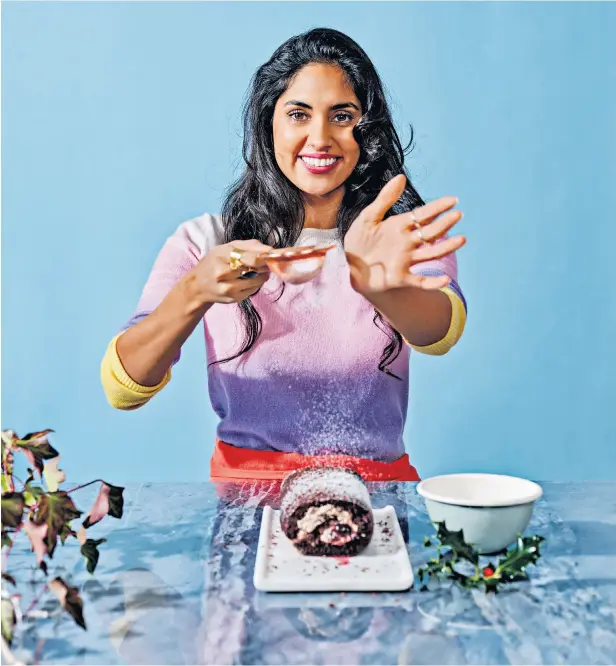  ??  ?? Ravneet Gill sprinkles a little Christmas stardust over her chocolate roulade with cherries and brandy; recipe overleaf