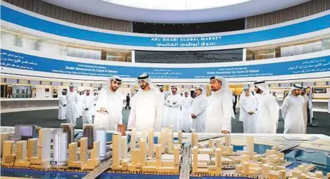  ?? WAM ?? Shaikh Mohammad speaks with staff while visiting the Abu Dhabi Global Market on Al Maryah Island. With him is Ahmad Ali Al Sayegh (centre right) and other officials. Shaikh Mohammad then toured ADGM with Al Sayegh.