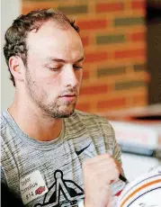  ?? THE OKLAHOMAN] [PHOTO BY NATE BILLINGS, ?? OSU quarterbac­k Taylor Cornelius signs a helmet during Fan Appreciati­on Day last weekend.