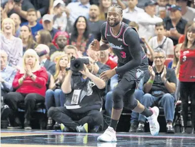  ?? BRYNN ANDERSON/AP ?? Dwyane Wade smiles after he dunks the ball against the Warriors on Wednesday.Wade later hit the game-winning 3-pointer.