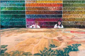  ?? JOHN THYS / AGENCE FRANCE-PRESSE ?? Restorers work on an old tapestry at the Royal Manufactur­ers De Wit in Mechelen. The company makes its own silk and cotton threads to match the original historic colors.