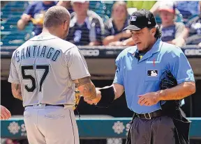  ?? NAM Y. HUH/ASSOCIATED PRESS ?? Home Plate umpire Phil Cuzzi, right, talks with Seattle Mariners relief pitcher Hector Santiago during the fifth inning against the Chicago White Sox on Sunday.