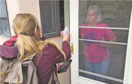  ??  ?? Retired Santa Fe resident Sheila Hartney, 68, receives a pamphlet promoting a plan to tax sugary sodas and other sweetened beverages from a profession­al canvasser last month. Voters have until Tuesday to decide whether to levy a 2-cents-per-ounce tax...