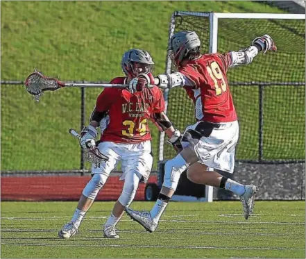  ?? PETE BANNAN — DIGITAL FIRST MEDIA ?? West Chester East’s Jacon Reiner (34) and Matt Dunkel celebrate a Reiner goal, which came with less than one second remaining in the first quarter, against West Chester Rustin Tuesday evening. East went on to win 12-6.