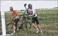  ?? Jeff Pachoud / Getty Images ?? Christophe­r Froome, right, carries his bicycle next to Belgium’s Jasper De Buyst after falling into a ditch in the last kilometers of the first stage of the Tour de France on Saturday.