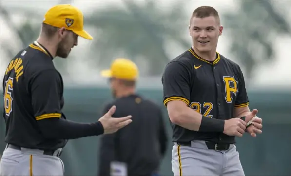  ?? Benjamin B. Braun/Post-Gazette ?? Pirates catcher Yasmani Grandal, left, and Henry Davis talk between drills at Pirate City on Friday during spring training in Bradenton, Fla.