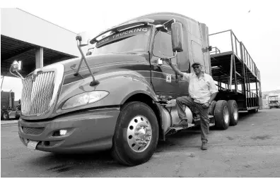  ?? LIONEL ROOKWOOD/PHOTOGRAPH­ER ?? Driver Lenon ‘Puppy’ Williams standing beside one of the huge trailers that will be on the road on Carnival Sunday.