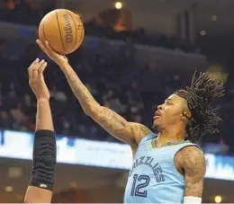  ?? BRANDON DILL AP ?? Grizzlies guard Ja Morant, who had 29 points, eight assists, five rebounds and two blocks, goes up for a shot Tuesday in the second half against the Warriors.