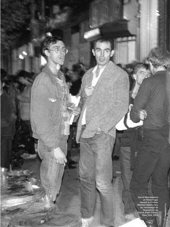  ??  ?? David Wojnarowic­z et Peter Hujar devant la Civilian Warfare Gallery lors du vernissage de l’exposition de David, East Village, New York, 1983