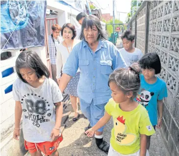  ?? APICHART JINAKUL ?? Nualnoi Timkul, who runs Ban Khru Noi, takes officials to inspect her charity home for children on Soi Rat Burana 26 to find ways to help children under her care as its closure looms on Sunday.
