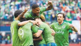  ?? Abbie Parr Getty Images ?? KELVIN LEERDAM, bottom center, is hugged by teammates after scoring.