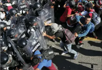  ?? MARCO UGARTE — THE ASSOCIATED PRESS ?? Migrants charge on Mexican National Guardsmen at the border crossing between Guatemala and Mexico in Tecun Uman, Guatemala, Saturday.