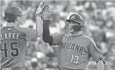  ?? RICHARD MACKSON/USA TODAY SPORTS ?? The Diamondbac­ks’ Nick Ahmed (13) celebrates his home run with pitcher Taylor Clarke in the second inning against the Dodgers at Dodger Stadium on Tuesday night. Visit dbacks.azcentral.com for a recap.