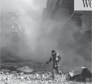  ?? ABDULMONAM EASSA / AFP / GETTY IMAGES ?? A civil defence volunteer checks the site of an airstrike in the rebel-held town of Saqba, in the Eastern Ghouta region outside of Damascus, on Friday. Another 32 civilians were killed in the sixth straight day of Syrian regime air strikes.