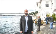  ??  ?? Turkish luxury real estate consultant Ugur Ayhan beside waterside mansions on the Bosphorus River coast.