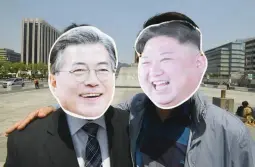  ??  ?? South Korean activists wearing masks of South Korean President Moon Jae-in (L) and North Korean leader Kim Jong Un (R) pose for a photo during a rally to support the upcoming inter-Korean summit, at Gwanghwamu­n square in Seoul on April 25, 2018. (AFP)