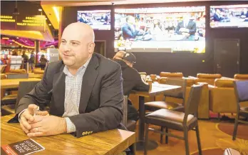  ??  ?? SugarHouse Vice President and general counsel Evan Davis says the sportsbook area he is sitting in is temporary, with a larger, permanent space coming this year.