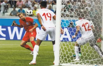  ?? Alastair Grant / Associated Press ?? Harry Kane heads in the deciding goal in the first minute of stoppage time during England’s 2-1 victory over Tunisia in their World Cup opener, England’s first World Cup win since 2010.