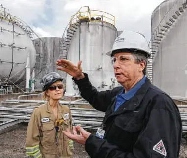  ?? Steve Gonzales photos / Houston Chronicle ?? Emerson executive account manager Randy Mobley, with OXEA Corp. senior instrument/electrical engineer Sherri Law, explains the workings of wireless transmitte­rs on a storage tank in Bay City.