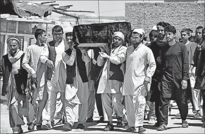  ?? THE ASSOCIATED PRESS] [MIRWAIS BAIZHAN/ ?? Men carry the coffin of one of the victims after Friday’s attack at a military compound in Mazar-e-Sharif province north of Kabul, Afghanista­n. Authoritie­s on Saturday raised the casualty toll to 100 in the attack on a military compound in northern...