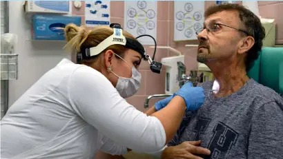  ?? AFP ?? Czech doctor Barbora repova inspects a hole in the throat of her patient, Martin Kozel, at Motol hospital, in Prague. —