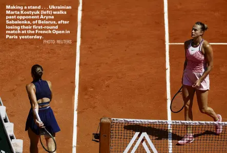  ?? PHOTO: REUTERS ?? Making a stand . . . Ukrainian Marta Kostyuk (left) walks past opponent Aryna Sabalenka, of Belarus, after losing their firstround match at the French Open in Paris yesterday.