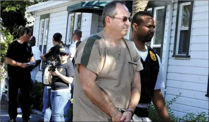  ??  ?? In this February 2011 photo, a DEA agent escorts Zvi Harry Perper to an awaiting police after his Delray Pain Management clinic was raided by agents in Delray Beach, Fla. CARLINE JEAN/ SOUTH FLORIDA SUN-SENTINEL VIA AP